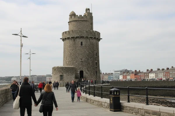 Martello Tower em Sandycove, Dublin, em um dia claro com algumas pessoas caminhando na orla, capturada por uma fotógrafa amadora.